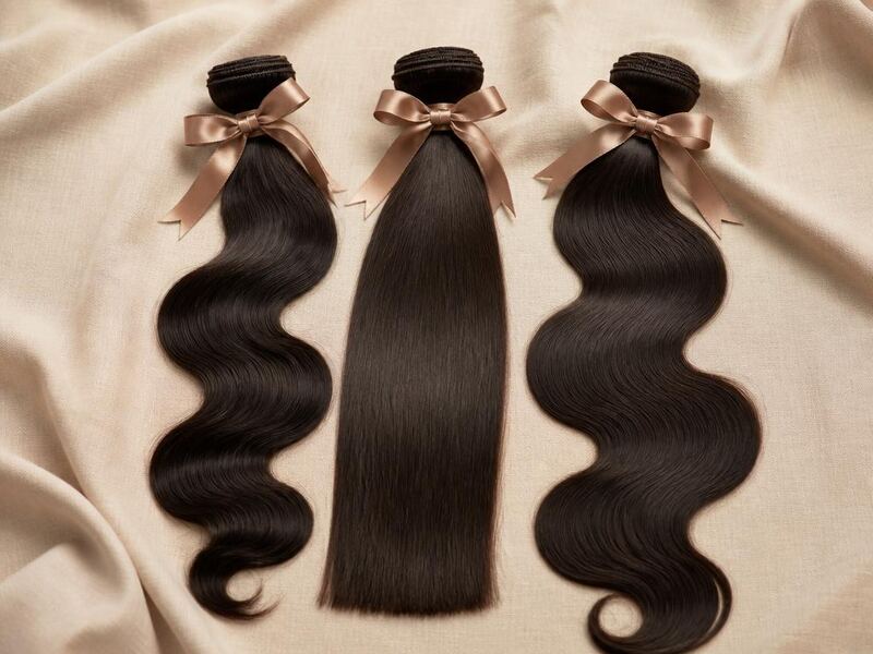 Three human hair weft bundles in straight and body wave textures tied with satin ribbon.