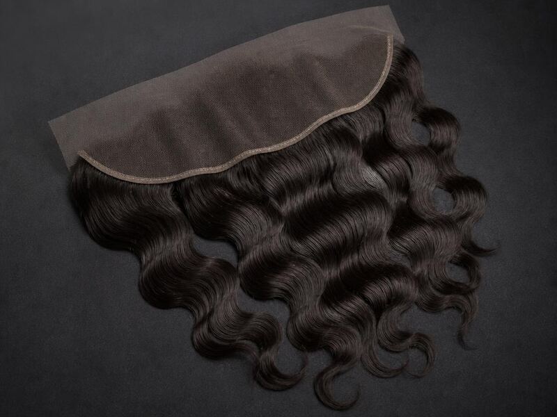 A 13x4 human hair lace frontal with body wave hair on a charcoal surface.