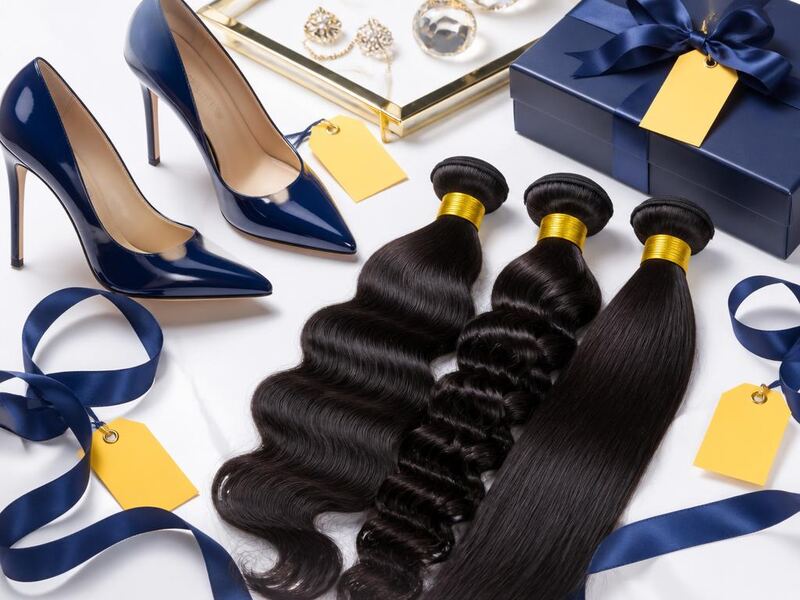 Navy patent heels and human hair bundles styled with yellow sale tags and navy ribbon.